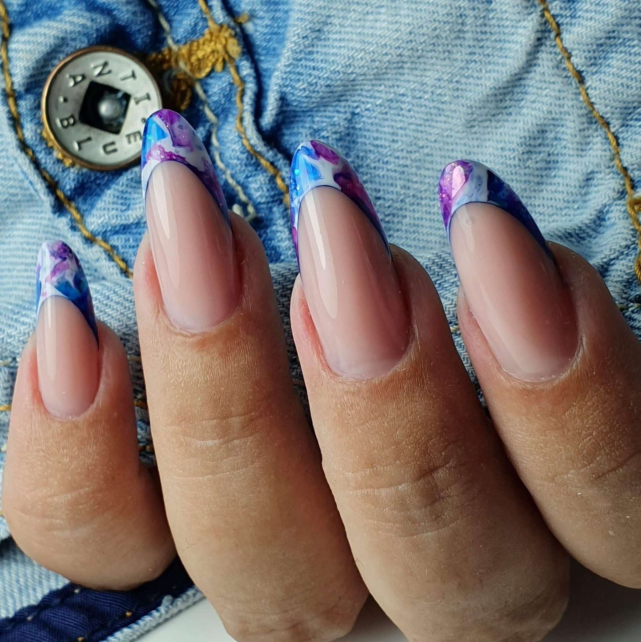 Amandelvormige nagels met een gekleurde French in paars en blauw marmer, op spijkerstof