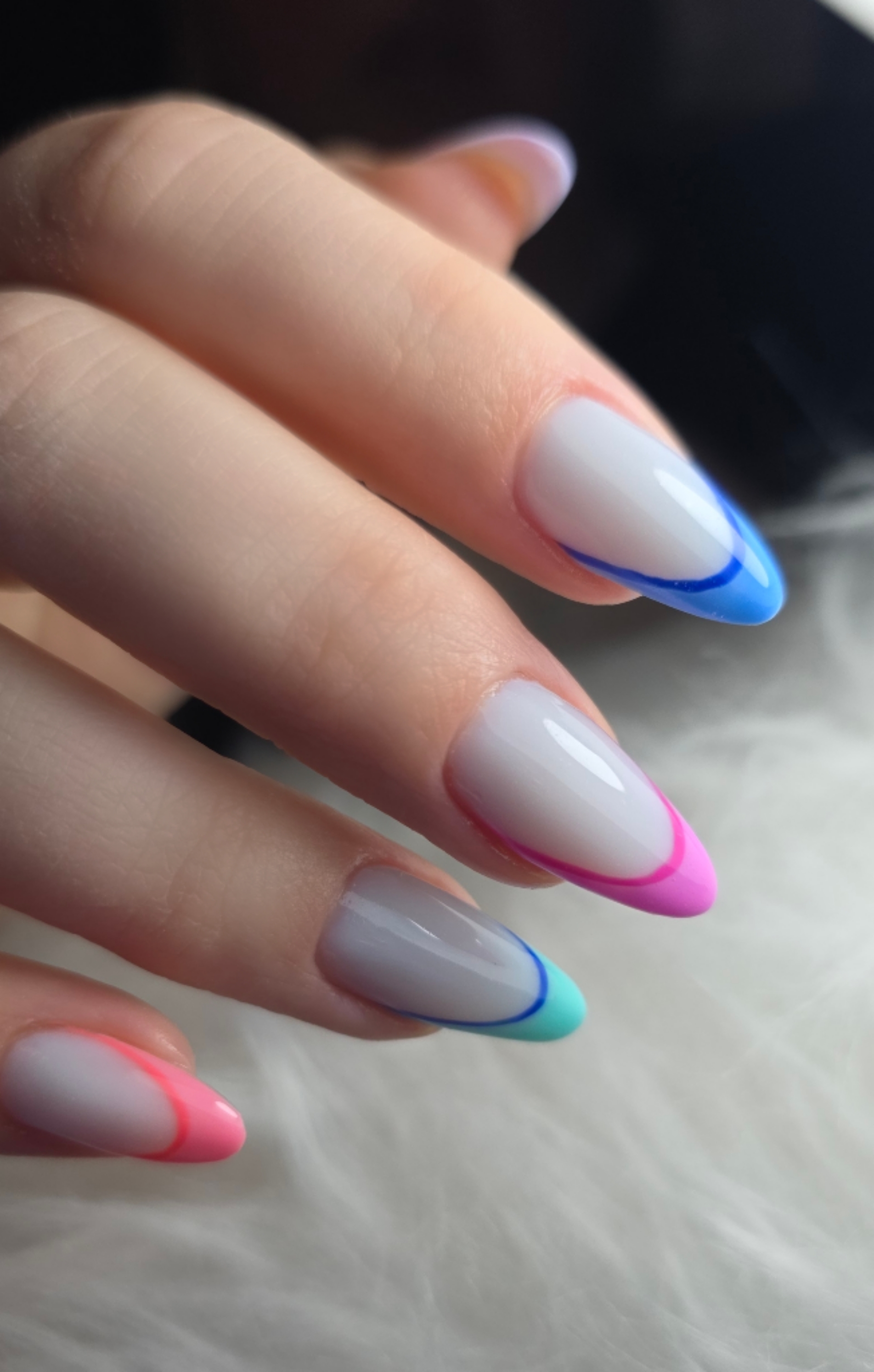 Lange amandelnagels met dunne French-randjes in blauw, roze en mint