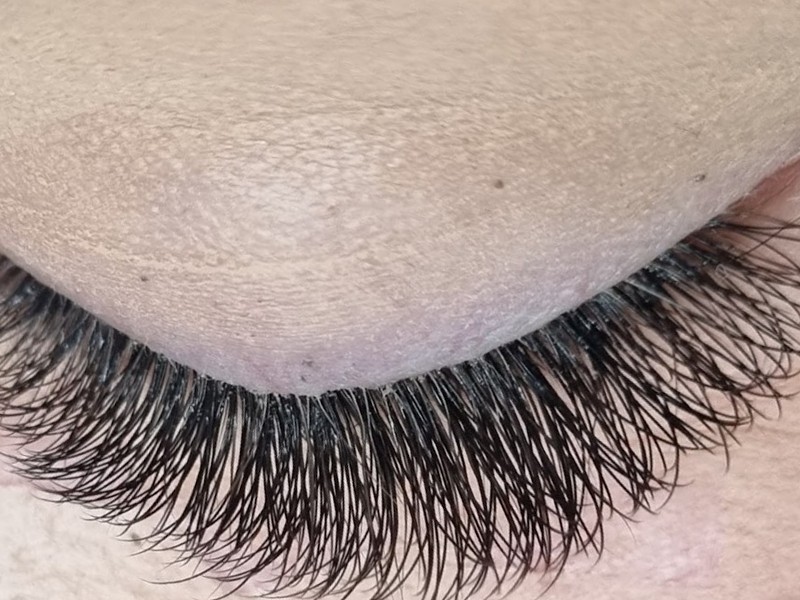 Close-up van een gesloten oog met volle wimperextensions